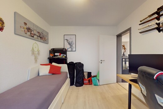 zimmer / schlafzimmer mit fernseher, wood finish floor, holzfußboden, inside property, und drywall