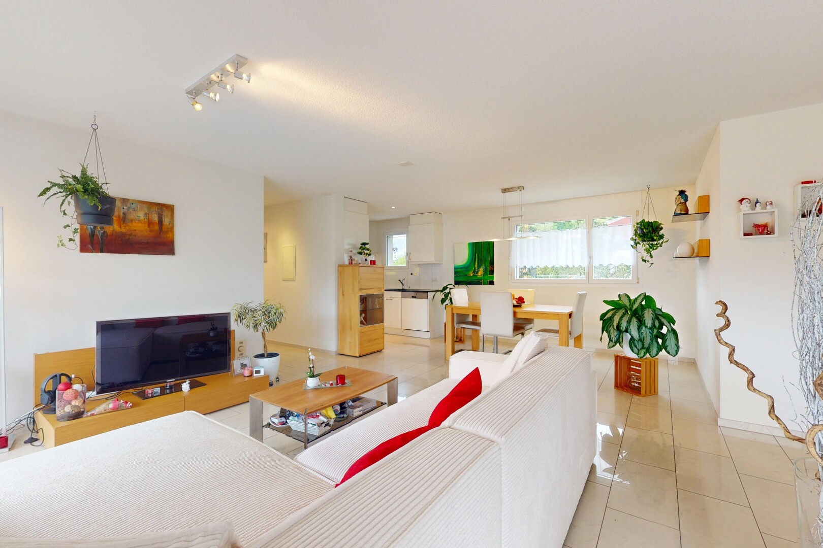 espace intérieur avec lumière naturelle, sol en carrelage, télévision, cloison sèche, et éclairage sur rail