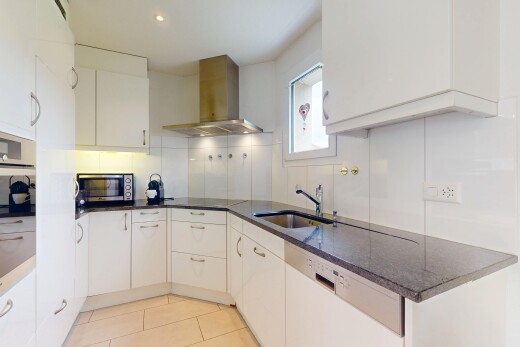 küche mit küchenrückwand beim herd, waschbecken, dunstabzugshaube, mikrowelle, und natürliches licht