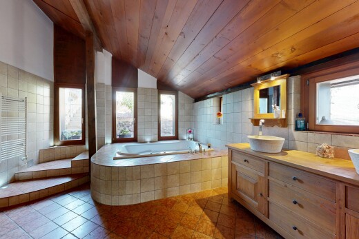 salle de bains avec vaulted ceiling, plafond voûté, miroir, tile wall, et mur en carrelage