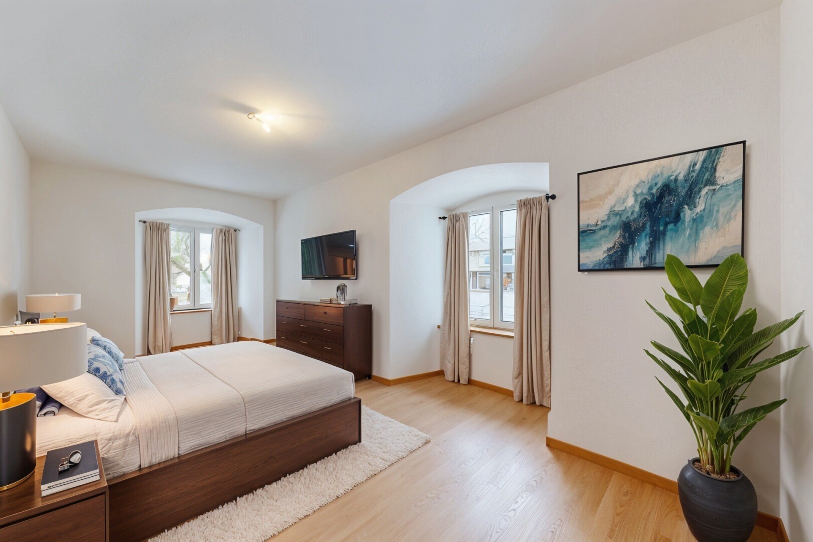 chambre avec cloison sèche, télévision, lumière naturelle, et sol en finition bois