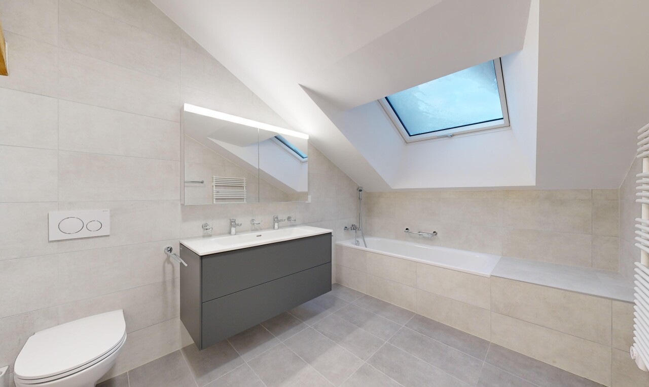 salle de bains avec plafond voûté, toilettes, baignoire, et miroir