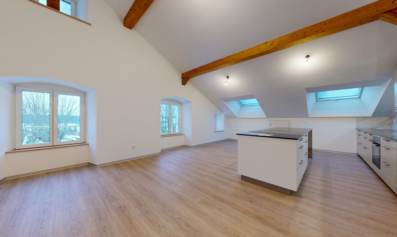 pièce vide avec lucarne, plafond voûté, lumière naturelle, et plancher de bois