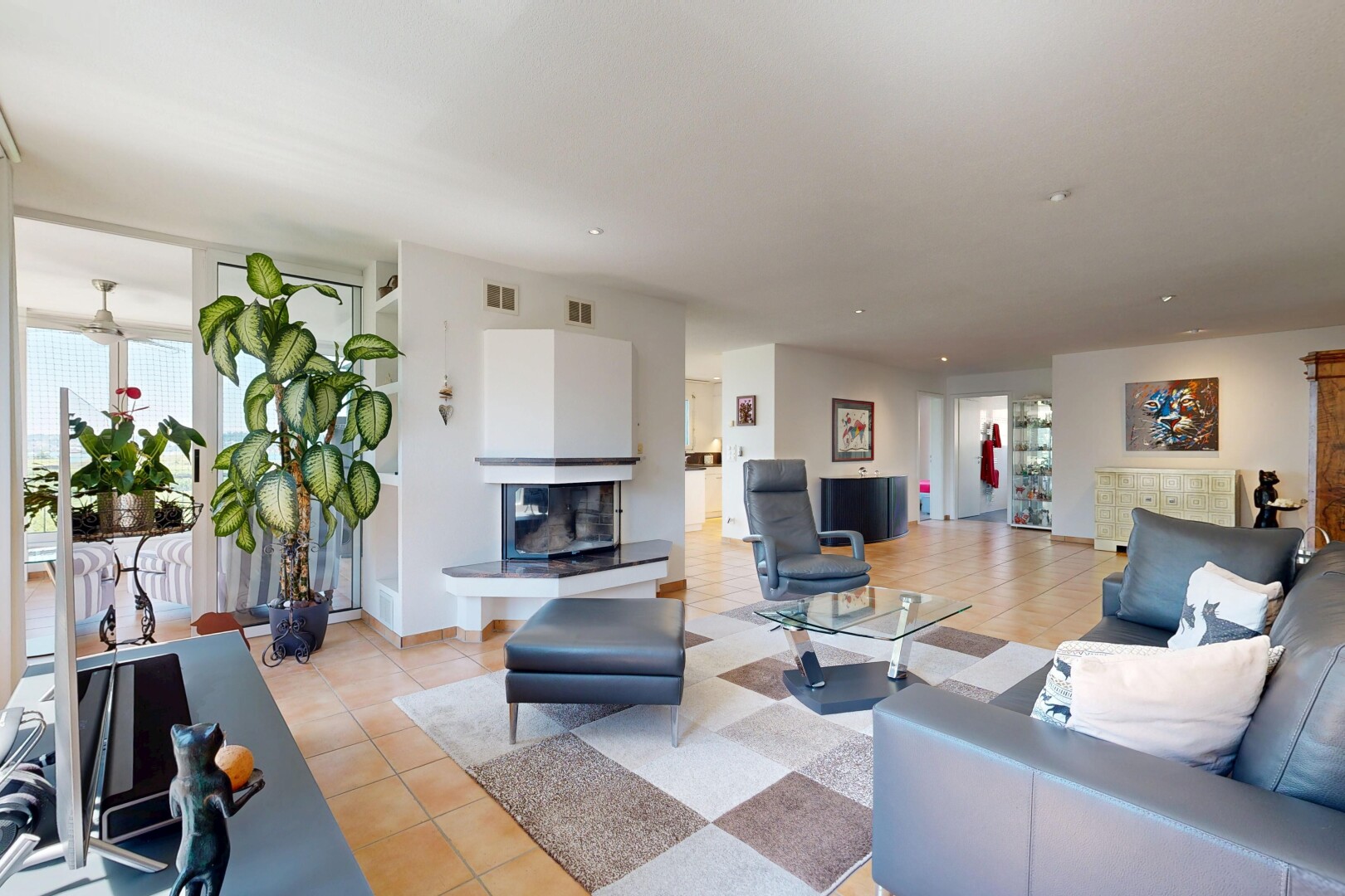 living room with a multi sided fireplace, healthy amount of natural light, and light tile patterned floors