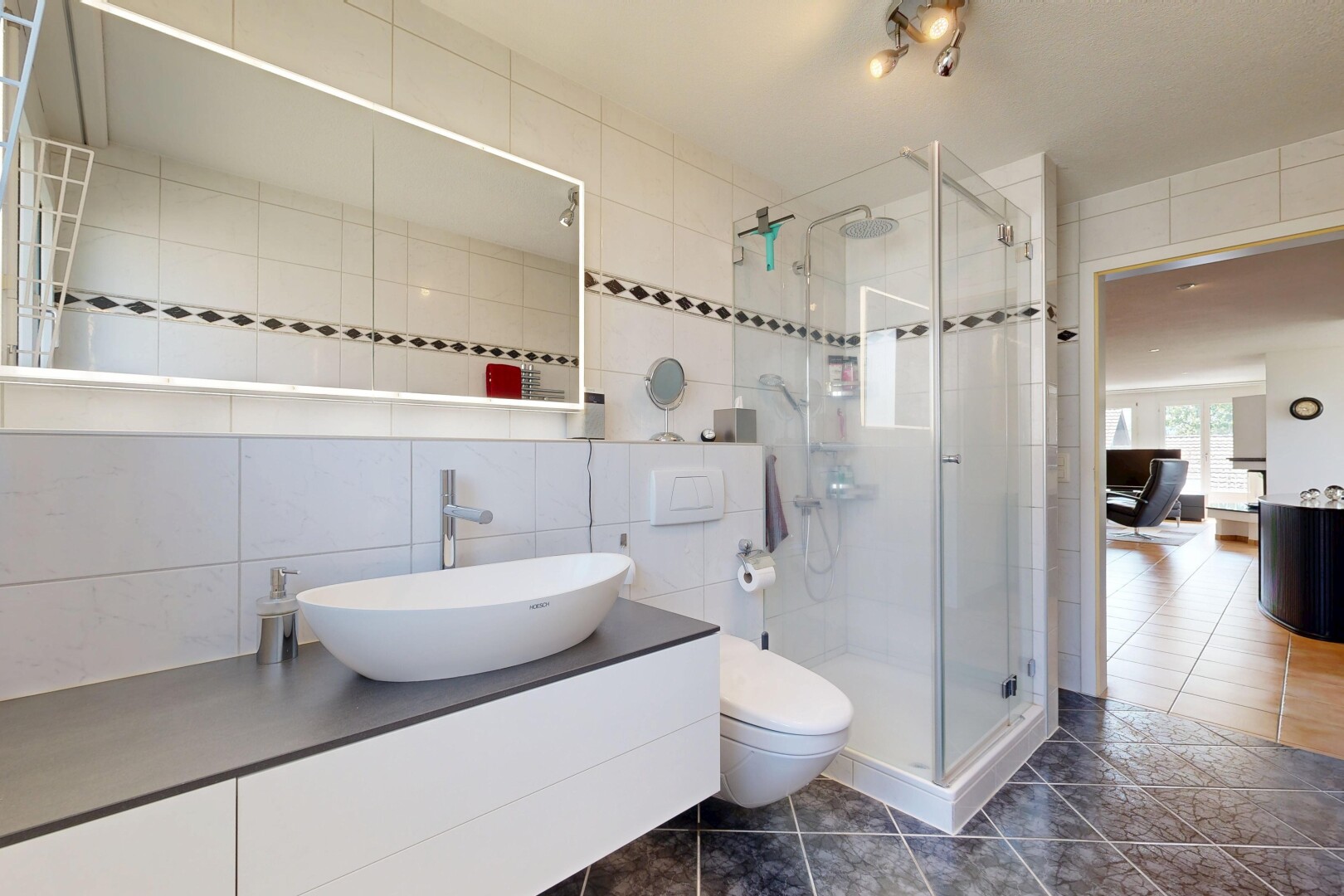 bathroom featuring tile walls, a shower stall, vanity, and dark tile patterned floors