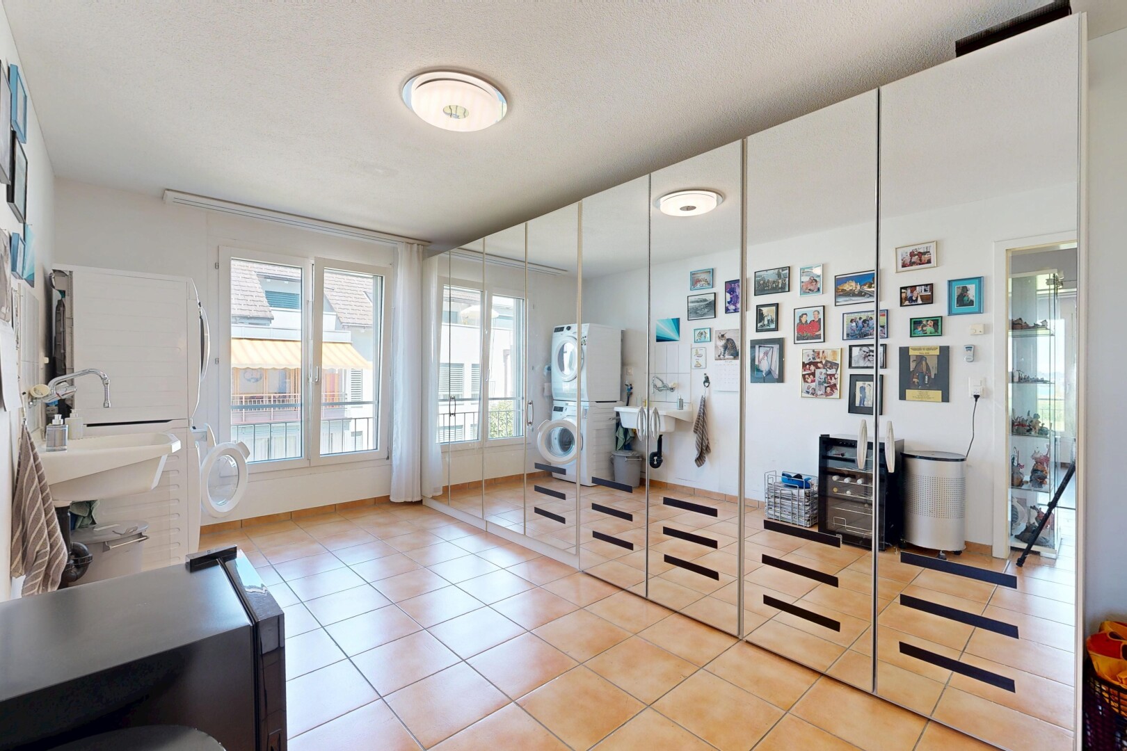 walk in closet with stacked washer and clothes dryer and light tile patterned flooring