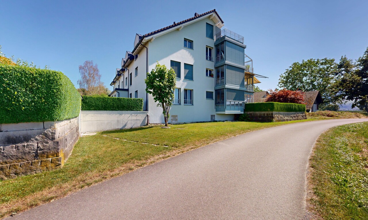 view of home with stucco siding and a lawn