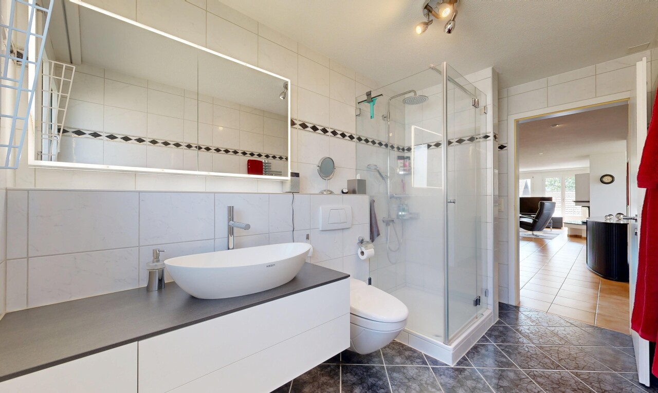 bathroom featuring tile walls, a shower stall, vanity, and dark tile patterned floors