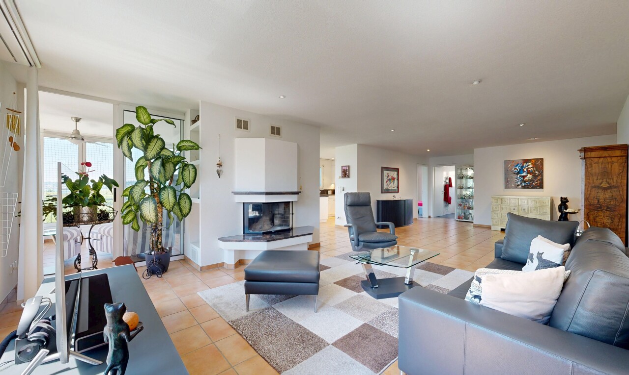 living room with a multi sided fireplace, healthy amount of natural light, and light tile patterned floors