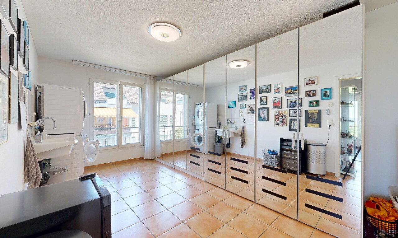 walk in closet with stacked washer and clothes dryer and light tile patterned flooring