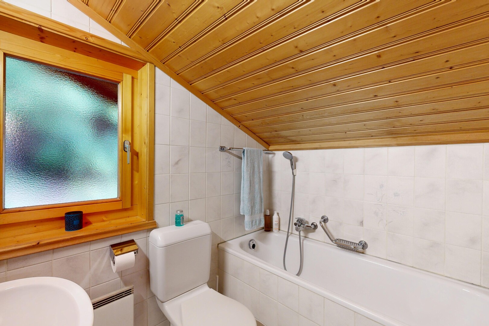 salle de bains avec tile wall, mur en carrelage, vaulted ceiling, plafond voûté, et bain