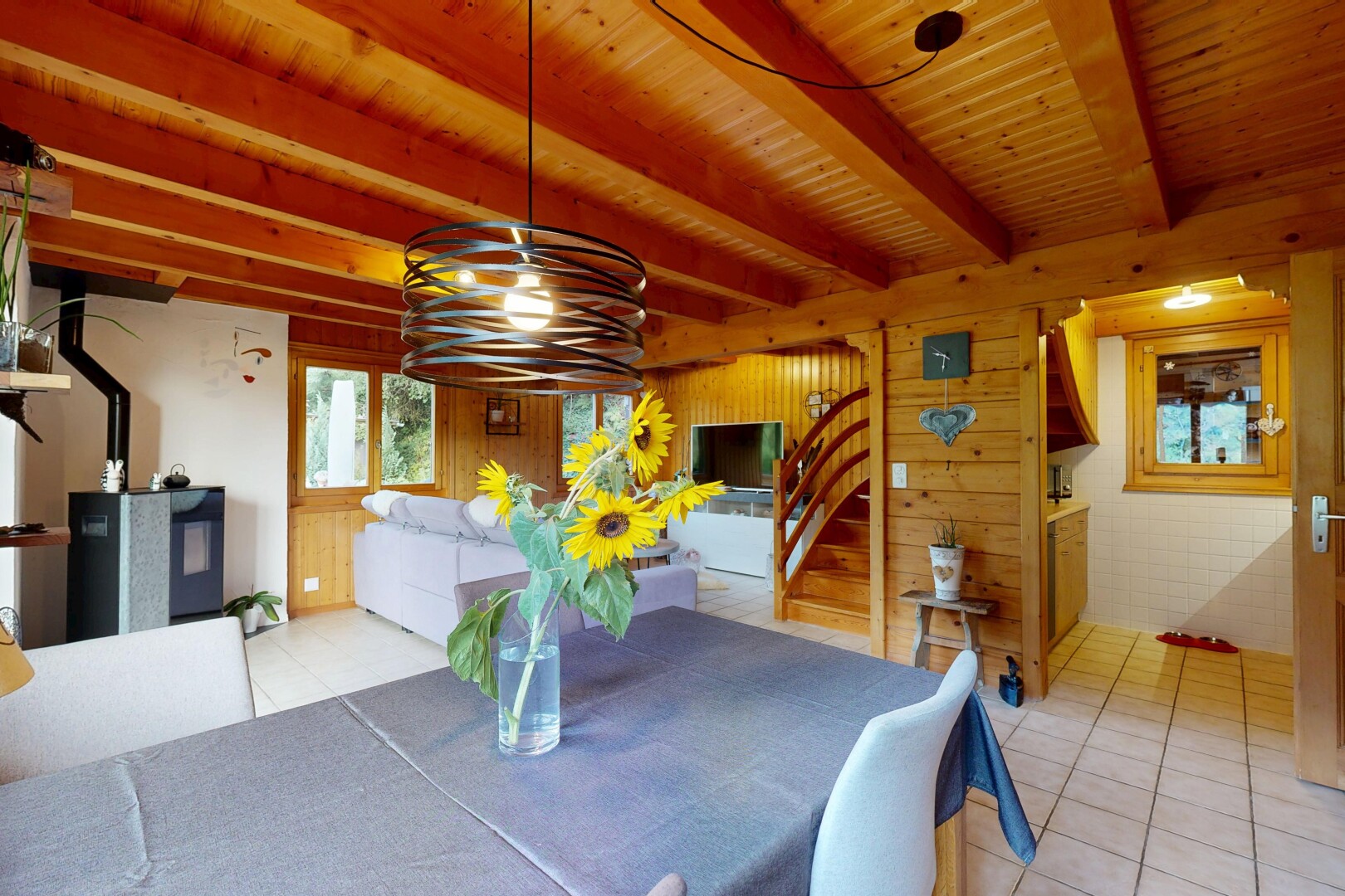 salle à manger avec escaliers, beamed ceiling, plafond à poutres, télévision, et tile floor