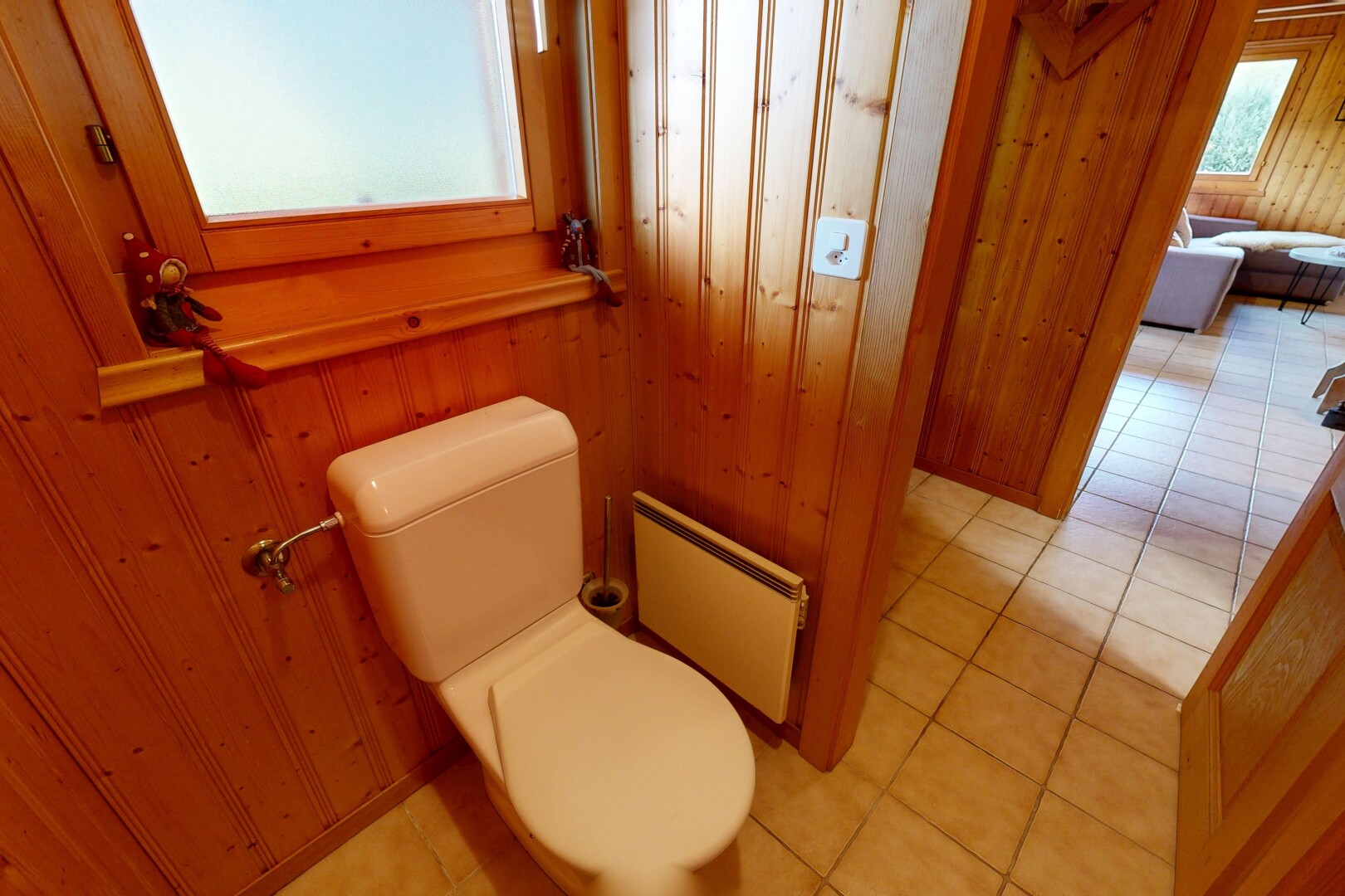 salle de bains avec dated wood wall, toilette, mur en bois, wood wall, et sol en carrelage