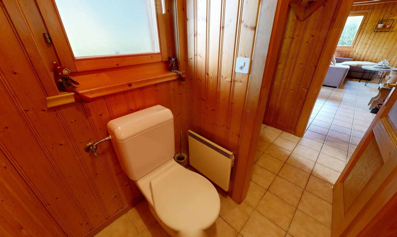 salle de bains avec dated wood wall, toilette, mur en bois, wood wall, et sol en carrelage