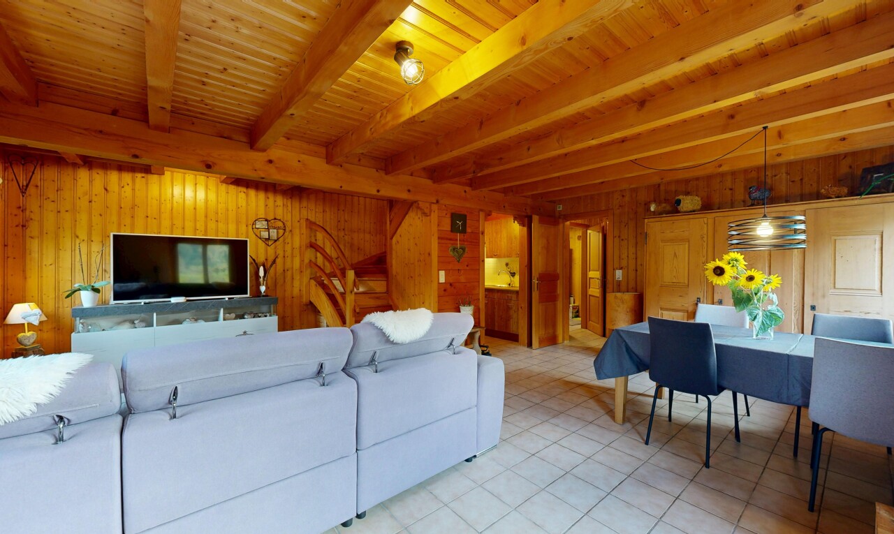 salon / salle à manger avec beamed ceiling, plafond à poutres, télévision, high end ceiling, et éclairage suspendu