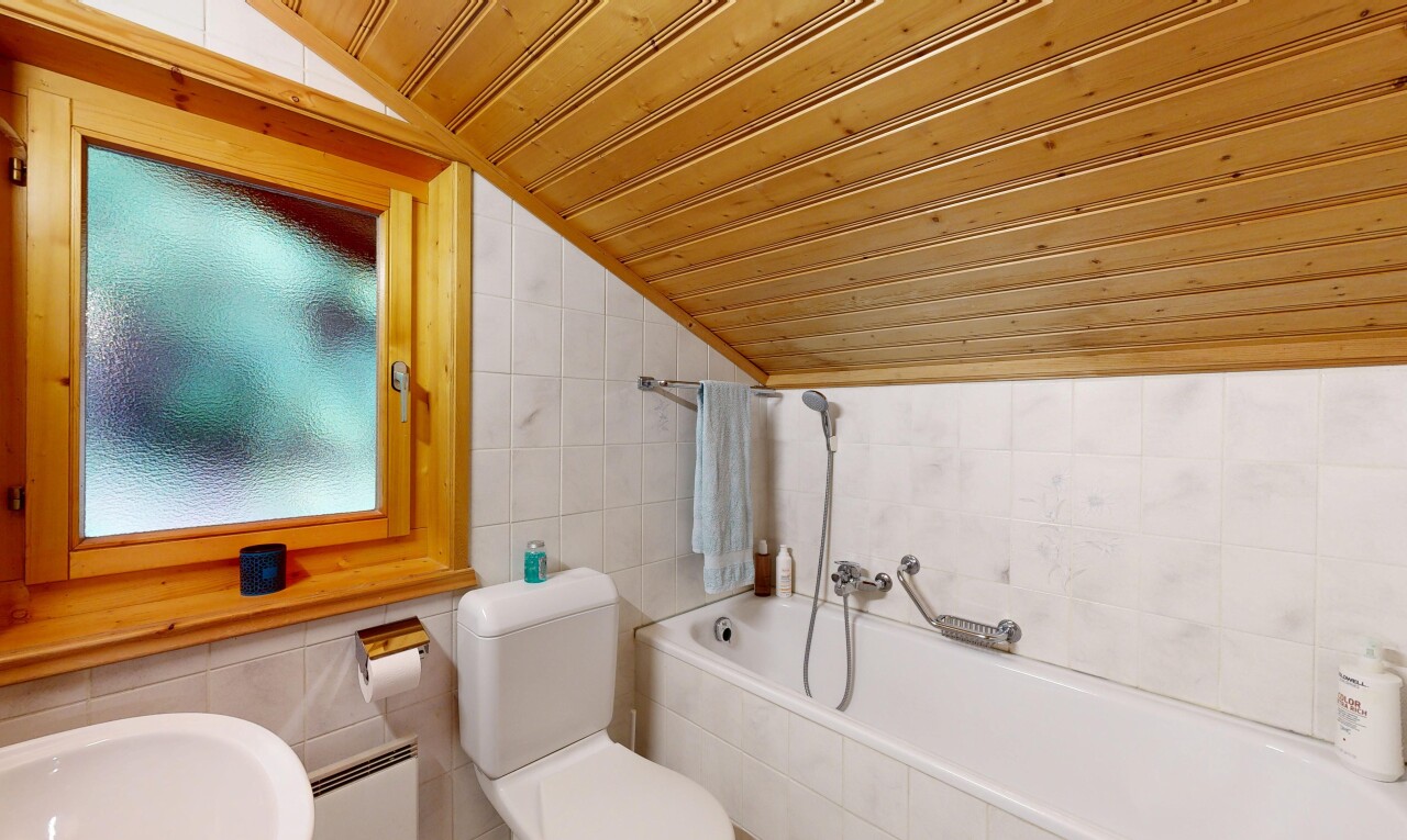 salle de bains avec tile wall, mur en carrelage, vaulted ceiling, plafond voûté, et bain