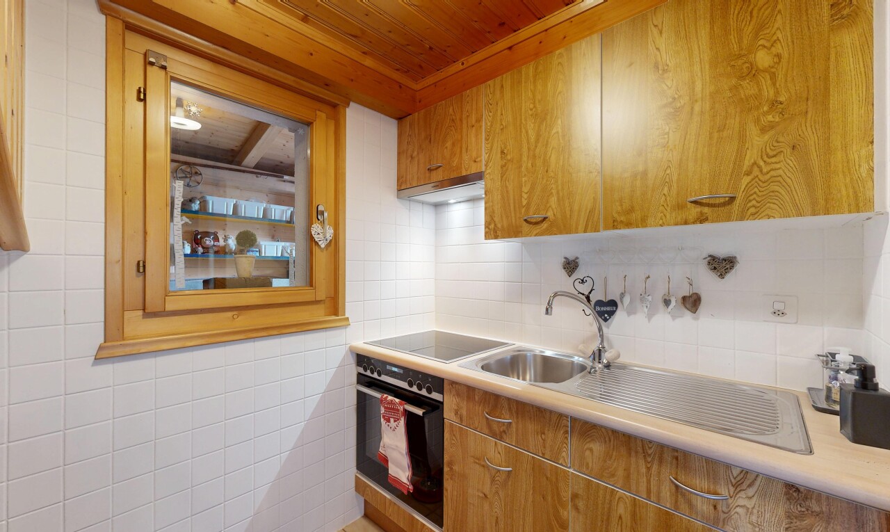 cuisine avec light countertops, plans de travail, medium brown cabinets, armoires marron moyen, et backsplash