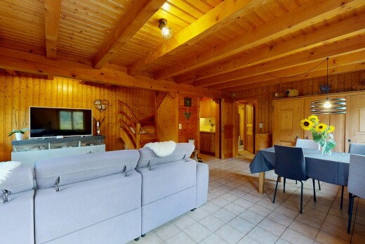 salon / salle à manger avec beamed ceiling, plafond à poutres, télévision, high end ceiling, et éclairage suspendu
