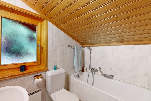 salle de bains avec tile wall, mur en carrelage, vaulted ceiling, plafond voûté, et bain