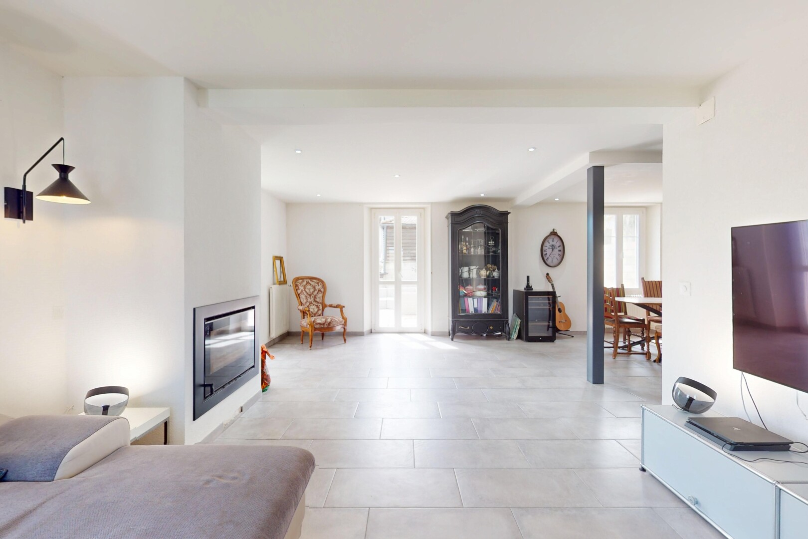 salon avec cheminée, lumière naturelle, sol en carrelage, cloison sèche, et télévision