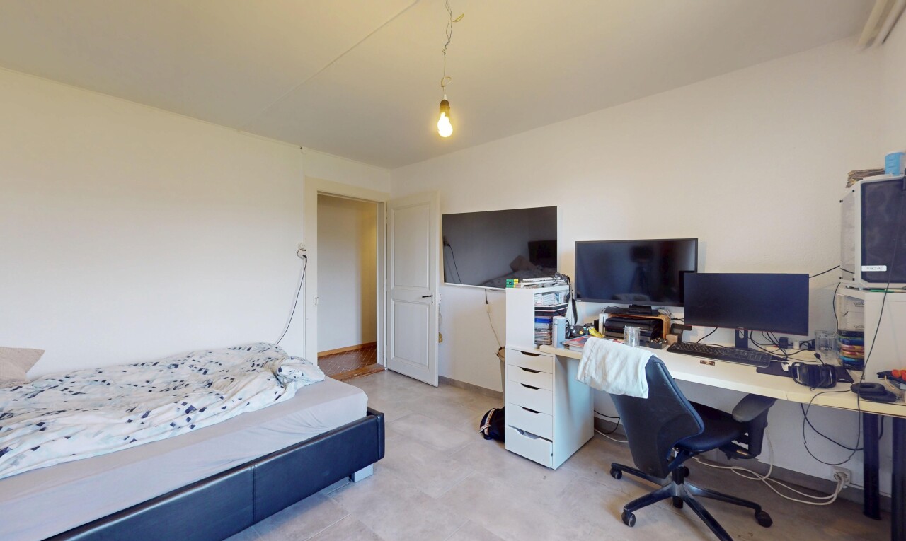 chambre avec cloison sèche, télévision, et espace bureau