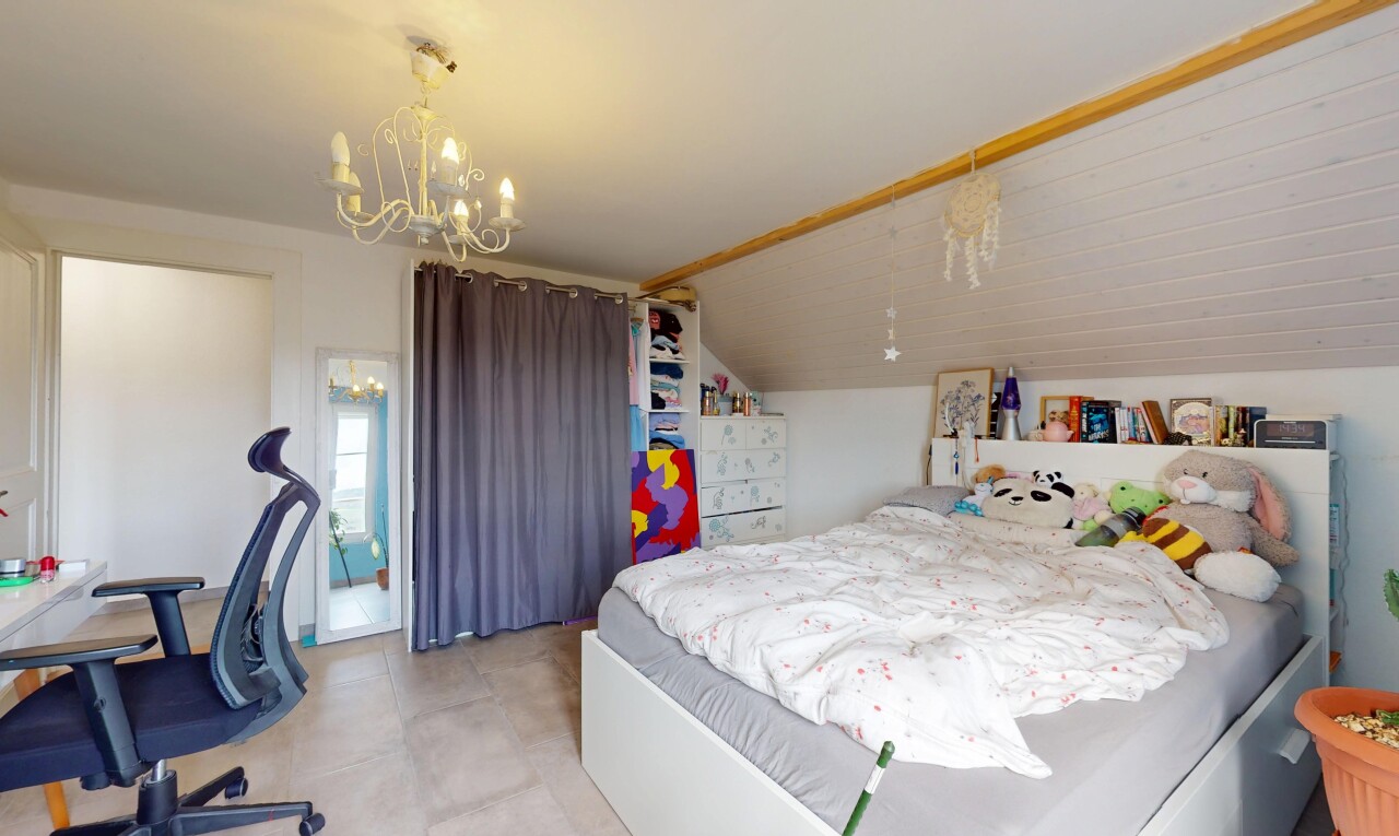 chambre avec cloison sèche, plafond bas, plafond voûté, lustre remarquable, et lumière naturelle