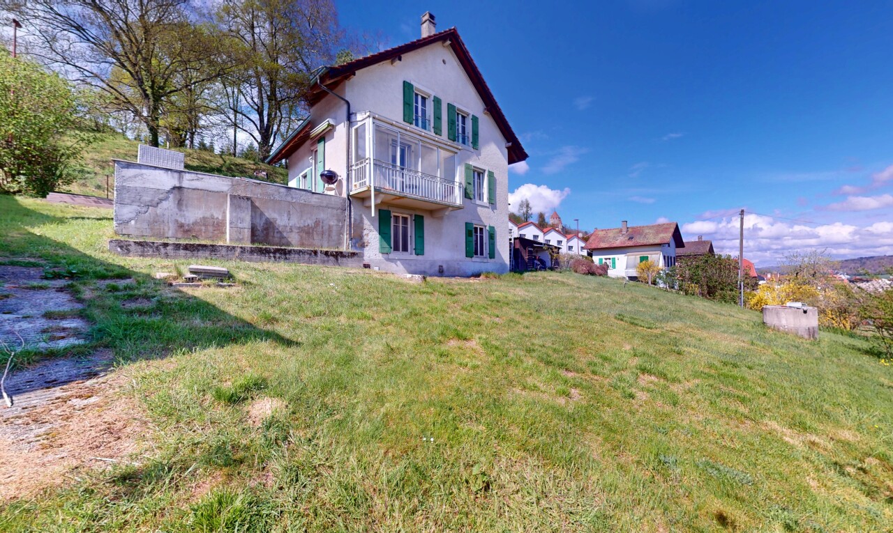 façade avec balcon, cheminée, bardage en stuc, et pelouse