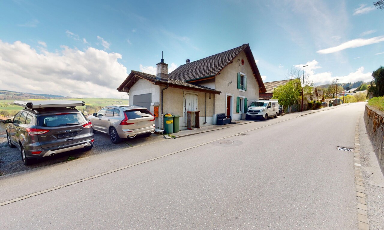 façade avec garage attaché, cheminée, et bardage en stuc