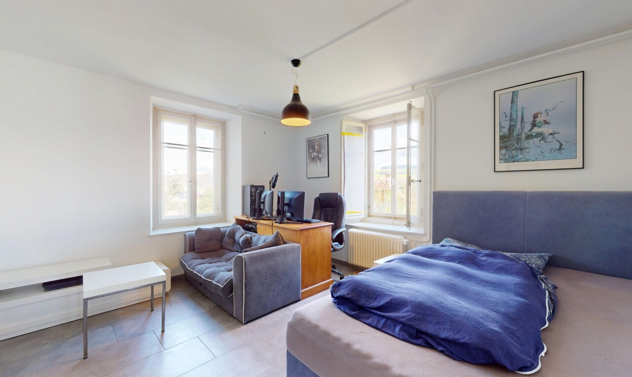 chambre avec télévision, lumière naturelle, radiateur, et cloison sèche