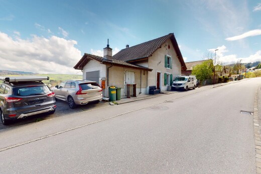 façade avec garage attaché, cheminée, et bardage en stuc
