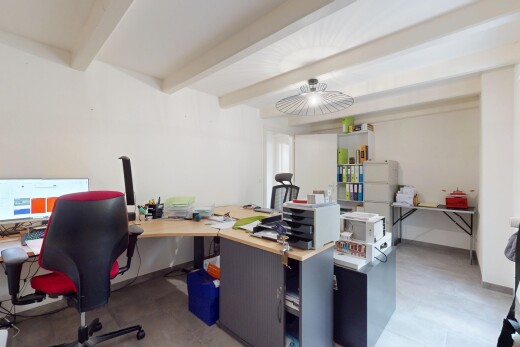 bureau avec télévision, espace bureau, plafond à poutres, et cloison sèche