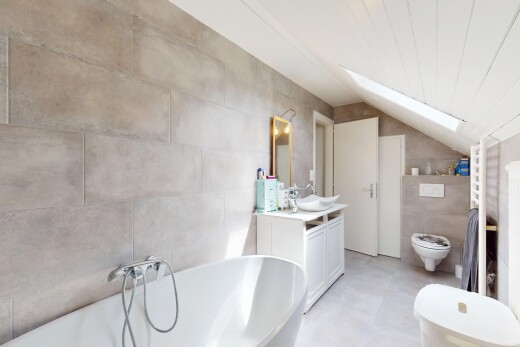 salle de bains avec salle de bain complète, bain, plafond voûté, miroir, et toilette