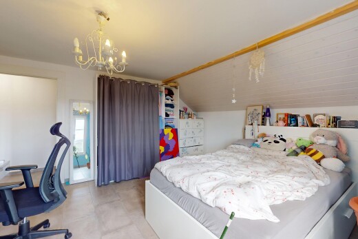 chambre avec cloison sèche, plafond bas, plafond voûté, lustre remarquable, et lumière naturelle