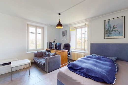 chambre avec télévision, lumière naturelle, radiateur, et cloison sèche