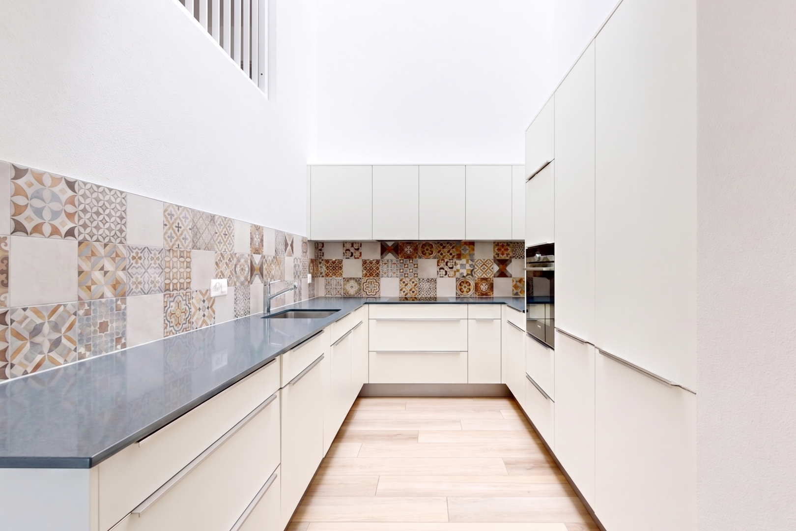 cuisine avec armoires à panneau plat, flat panel cabinets, dark countertops, armoires blanches, et white cabinets