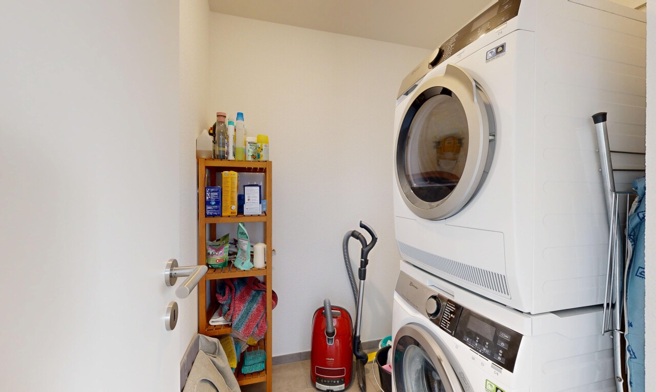 buanderie avec lave-linge et sèche-linge superposés, drywall, cloison sèche, inside property, et buanderie