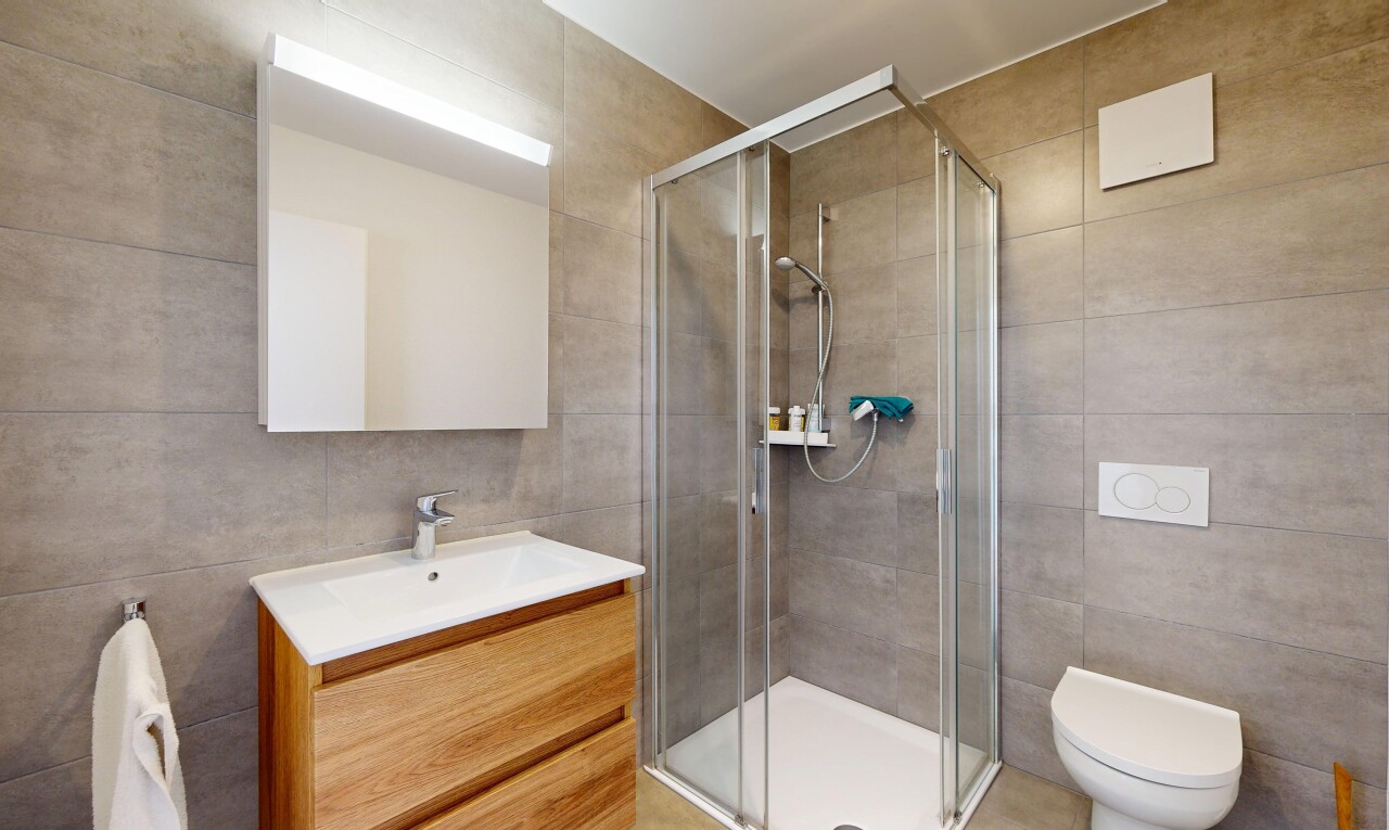 salle de bains avec tile wall, mur en carrelage, lavabo (ou coiffeuse selon le contexte), douche, et salle de bain complète
