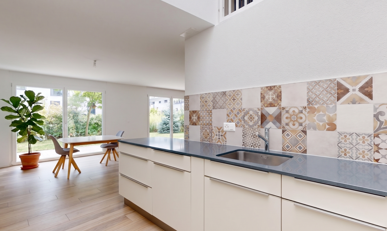 cuisine avec dark countertops, backsplash, dosseret, évier, et natural light