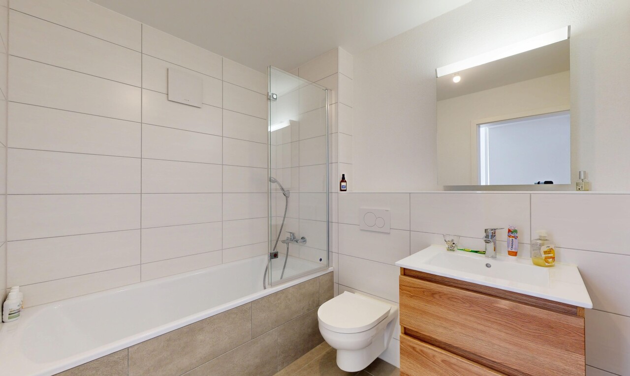 salle de bains avec tile wall, mur en carrelage, lavabo (ou coiffeuse selon le contexte), salle de bain complète, et inside property