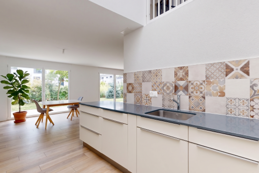 cuisine avec dark countertops, backsplash, dosseret, évier, et natural light