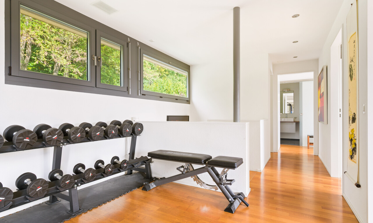 fitnessstudio mit wood finish floor, holzfußboden, inside property, natural light, und natürliches licht