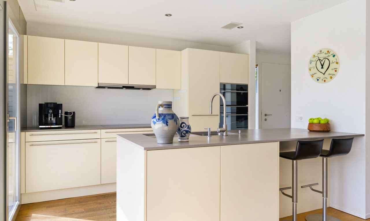 küche mit cremefarbene schränke, wood finish floor, holzfußboden, inside property, und küchenbar