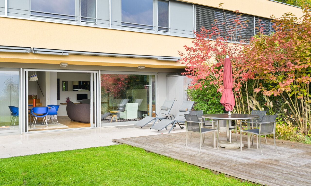 außenansicht mit property visible, stuckverkleidung, essbereich im freien, rasen, und deck