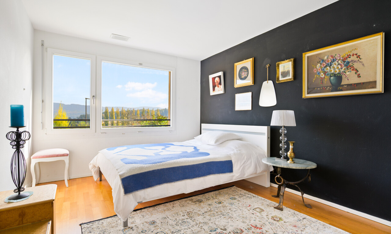 zimmer / schlafzimmer mit drywall, gipskartonwand, natural light, natürliches licht, und wood finish floor