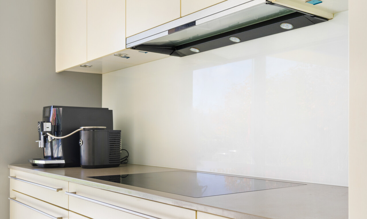 küche mit dunstabzugshaube, weiße schränke, herd, und inside property