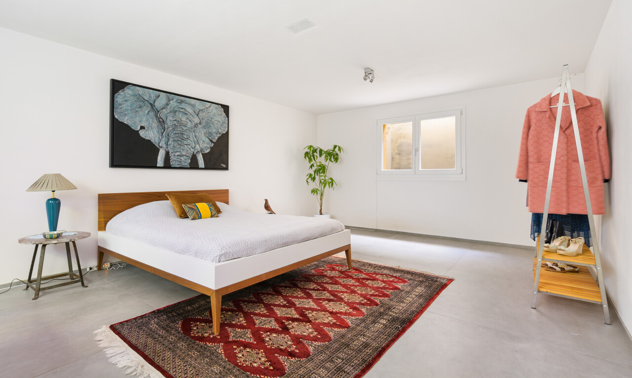 zimmer / schlafzimmer mit natural light, natürliches licht, concrete floor, betonboden, und inside property