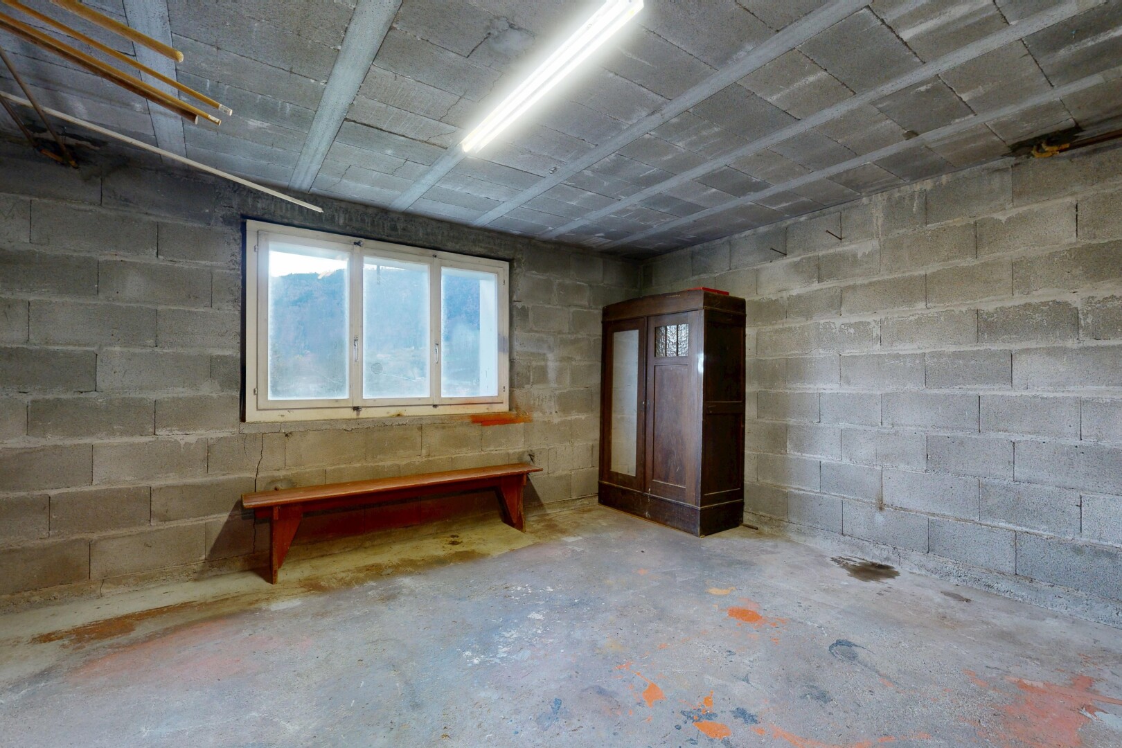 pièce vide avec unfinished concrete floor, sol en béton, concrete floor, mur en blocs de béton, et concrete block wall