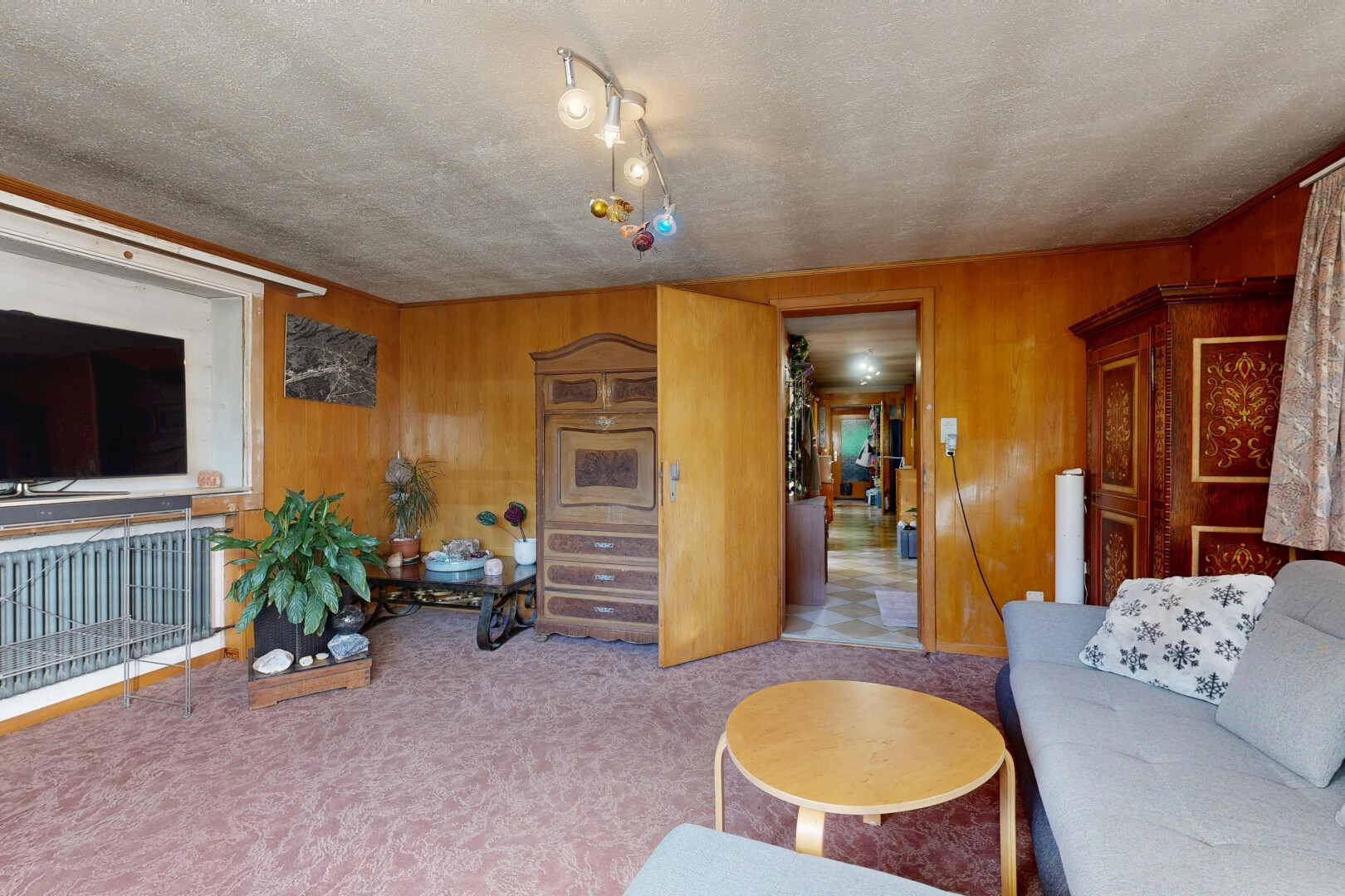 salon avec télévision, carpet, moquette, wood wall, et mur en bois