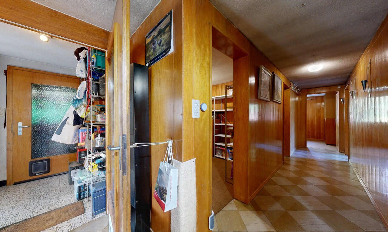 couloir avec inside property, wood wall, mur en bois, vinyl floor, et sol en vinyle
