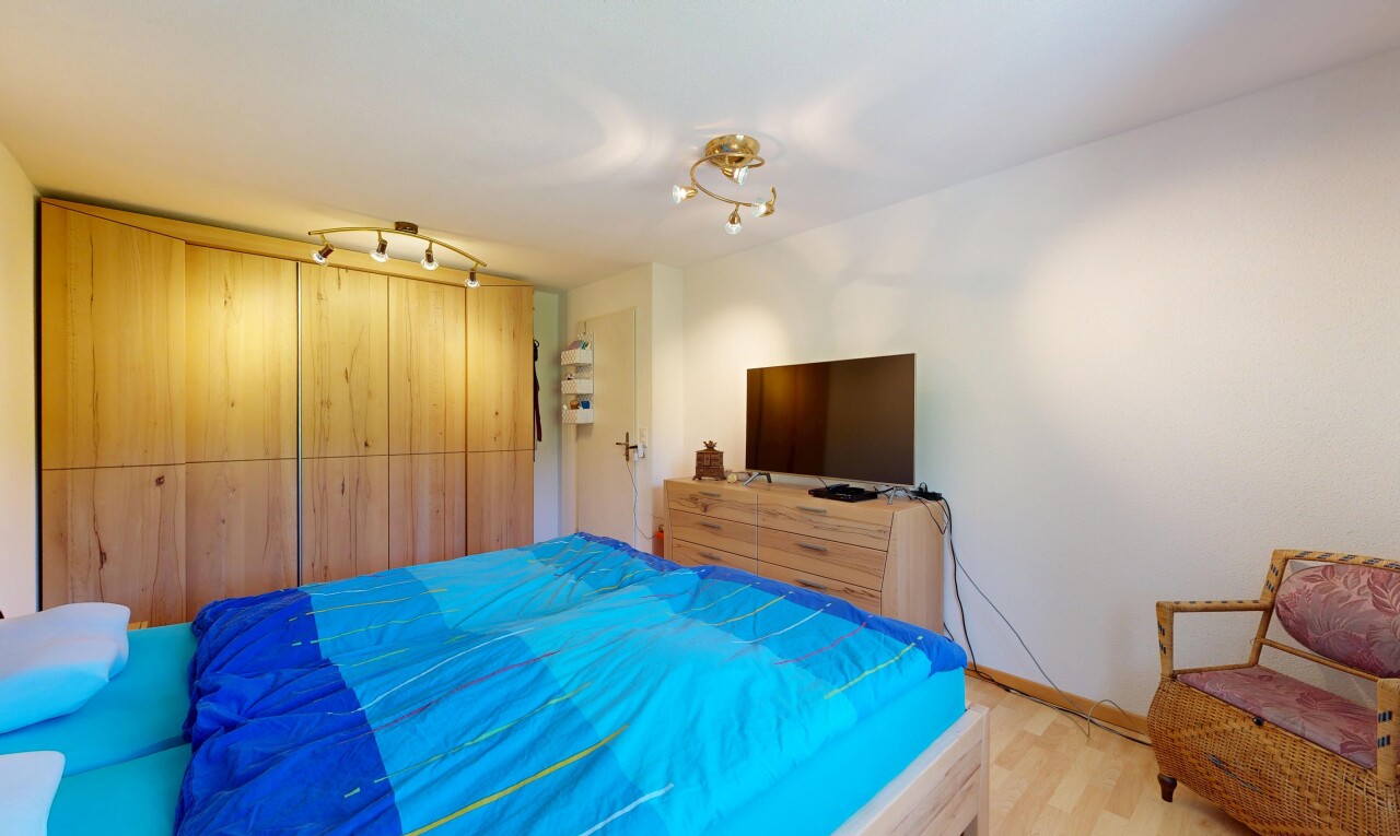 zimmer / schlafzimmer mit fernseher, inside property, gipskartonwand, drywall, und holzfußboden